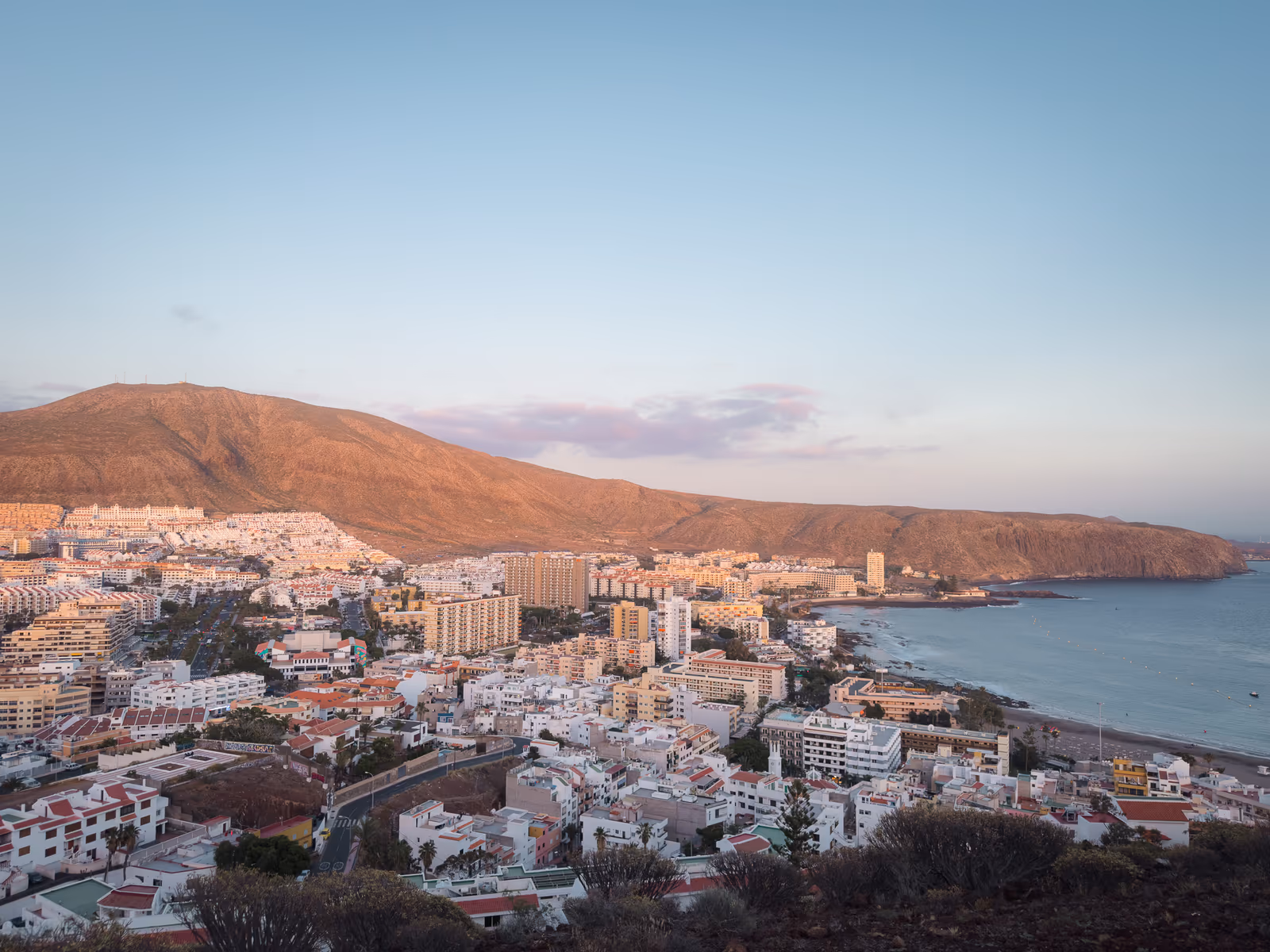 Vista aérea de Los Cristianos al atardecer con la Montaña de Guaza y el mar, Tenerife sur